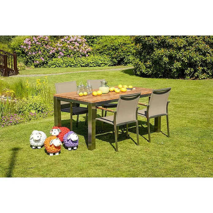 Kai Wiechmann Gartenstuhl - Stapelbar, Silber, B x T x H: 57 x 56 x 87 cm - Ein Gartentisch mit vier Stühlen, dekoriert mit Zitronen und Getränken, umgeben von bunten Schafdekorationen auf einem Rasen.