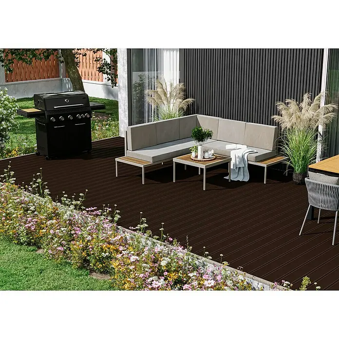 Kovalex WPC-Terrassendiele Exklusiv nach Maß - 420 x 14,5 x 2,6 cm, Schokobraun - Eine stilvolle Gartengestaltung mit Grill, Lounge-Ecke und blühenden Blumen. Die dunkle Holzterrasse verbindet alles harmonisch.