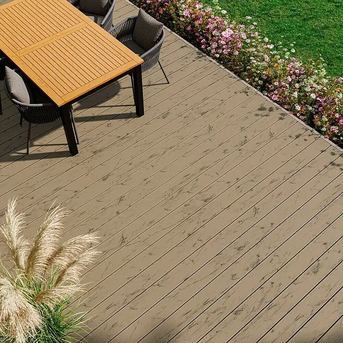 Kovalex WPC-Terrassendiele Massiv mit Struktur nach Maß - Samtesche, 540 x 14,5 x 2 cm - Hochwinkelaufnahme von Verbundholzterrasse mit Tisch und Stühlen, ideal für den Außenbereich. Die Terrassendielen verleihen dem Garten eine elegante Note.