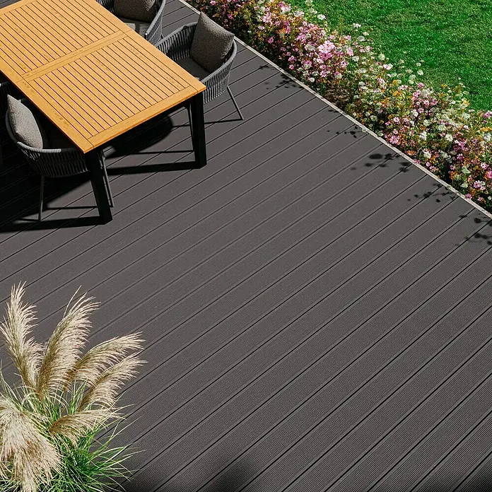 Kovalex WPC-Terrassendiele Exklusiv nach Maß - Grau, Gebürstet, 320 x 14,5 x 2,6 cm - Einladende Terrasse mit stilvollem Esstisch und robustem grauem Terrassenboden, ideal für entspannte Stunden im Freien.