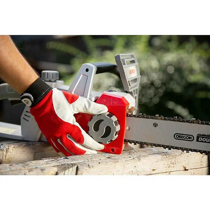 Ikra Akku-Kettensäge ICC 2/2035 - 40 V, 2 Ah, Li-Ionen, 2 Akkus - Nahaufnahme einer Kettensäge mit Oregon-Kette, die von einer Hand mit rotem Handschuh bedient wird.