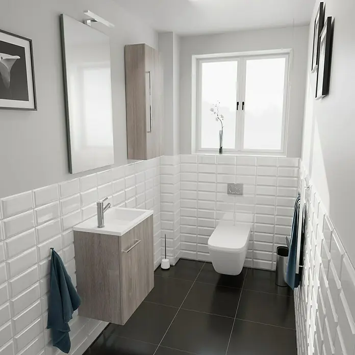 Camargue Espacio Badmöbel-Set H67 - 90 cm, Faro - Helles Badezimmer mit einer modernen Toilette, einem Waschbeckenunterschrank in Holzoptik und weißen Metrofliesen für eine saubere Ästhetik.