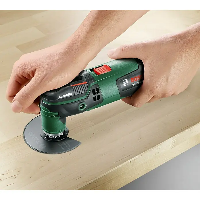 Bosch Multiherramienta PMF 250 CES - 250 W, Sistema STARLOCK - Primer plano de la herramienta multifunción Bosch PMF 250 CES cortando madera con una hoja de sierra para madera dura.