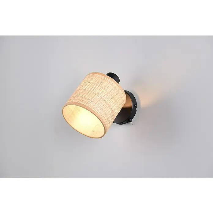 Trio Lighting Foco de pared Aimee - 20 W, L x An x Al: 13 x 10 x 25 cm, Beige, E14 - Una lámpara de pared iluminada que presenta una pantalla cilíndrica con un tejido de ratán claro y un soporte negro en una pared gris clara.