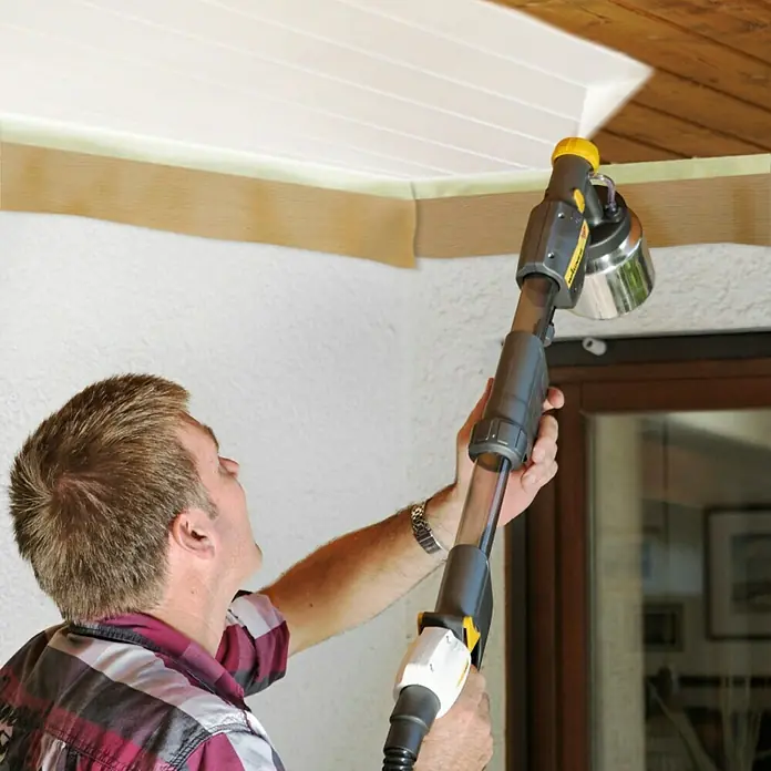 Wagner Griffverlängerung Universal EXTRA Extension - Länge: 60 cm - Mann benutzt eine Wagner Farbspritzpistole mit Teleskopverlängerung zum Streichen einer Decke. Das Gerät ermöglicht komfortables Arbeiten in der Höhe.