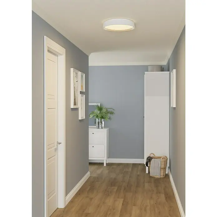 Eglo connect.z LED-Deckenleuchte rund Massignano-Z - 22 W, Ø x H: 15,75 x 2,56 cm, Weiß, RGBW - Flurlampe: Eine moderne, runde Deckenleuchte mit warmem Licht erhellt einen Flur mit Holzboden und grauen Wänden.