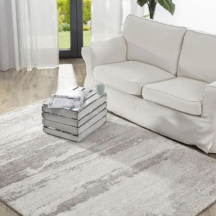 Dekoria Flachgewebeteppich - grau, creme, 170 x 120 cm - Elegante Nahaufnahme eines Wohnzimmers mit einem stilvollen Teppich, einem weißen Sofa und einem dekorativen Beistelltisch mit Zeitschriften.