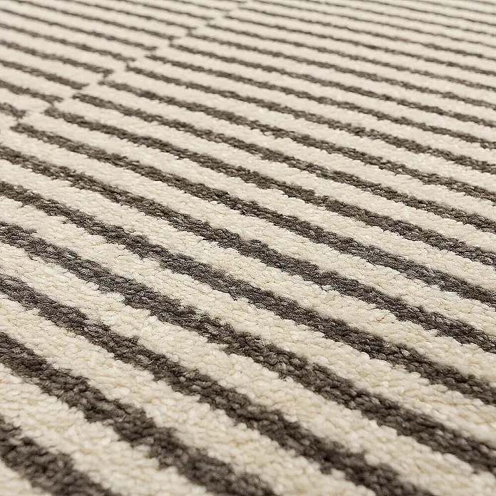 Dekoria Flachgewebeteppich - grau, creme, 170 x 120 cm - Nahaufnahme eines Teppichs mit grau-weißen Streifen. Der Teppich hat ein subtiles Zickzackmuster und eine weiche Textur.