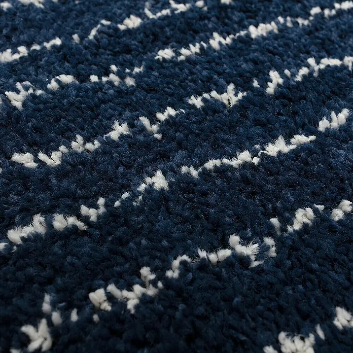Dekoria Flachgewebeteppich - dunkelblau, 170 x 120 cm - Nahaufnahme eines marineblauen Teppichs mit weißen Zickzackmuster. Der Teppich hat eine weiche, flauschige Textur.