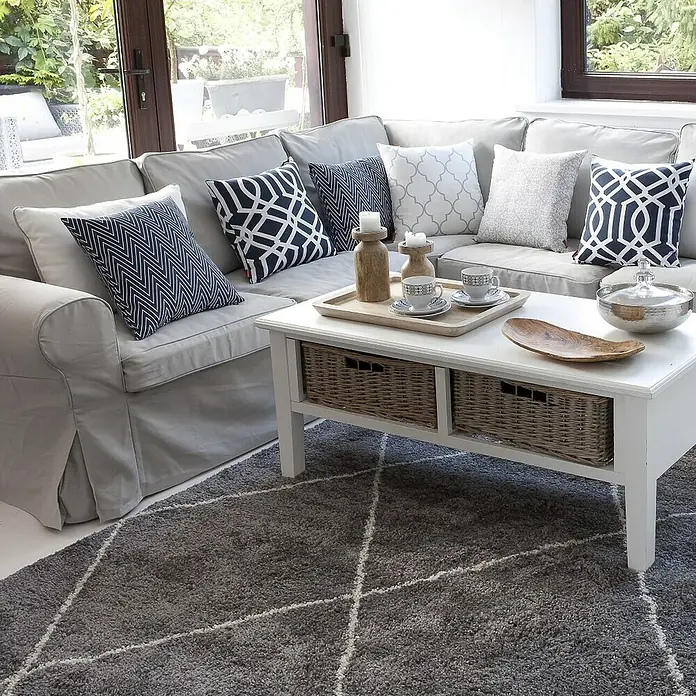 Dekoria Flachgewebeteppich - grau, 230 x 160 cm - Wohnzimmer-Interieur mit einem grauen Sofa, gemusterten Kissen und einem weißen Couchtisch auf einem geometrischen Teppich.