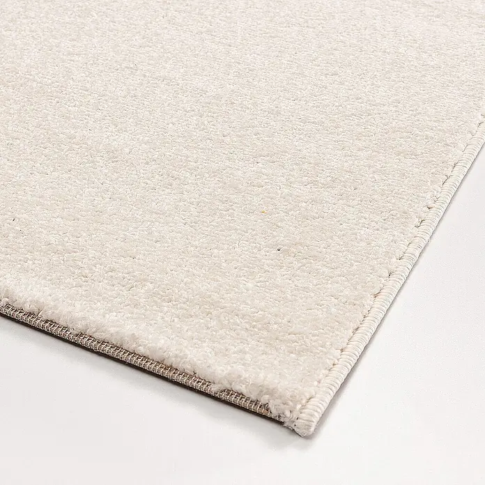 Dekoria Flachgewebeteppich - creme, 170 x 120 cm - Nahaufnahme eines beigen Teppichs mit weicher Textur und sauberer Kante. Ideal für Wohnräume.