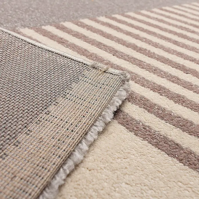 Dekoria Flachgewebeteppich - pink, beige, bunt, 230 x 160 cm - Detailansicht eines gestreiften Teppichs mit hochgeklappter Ecke, der die Unterseite und die Textur des Teppichs zeigt.
