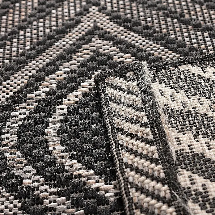 Dekoria Flachgewebeteppich - schwarz, 170 x 120 cm - Nahaufnahme eines Teppichs mit einem schwarz-weißen geometrischen Muster. Der Teppich hat einen Rand mit einem dekorativen Stichmuster.