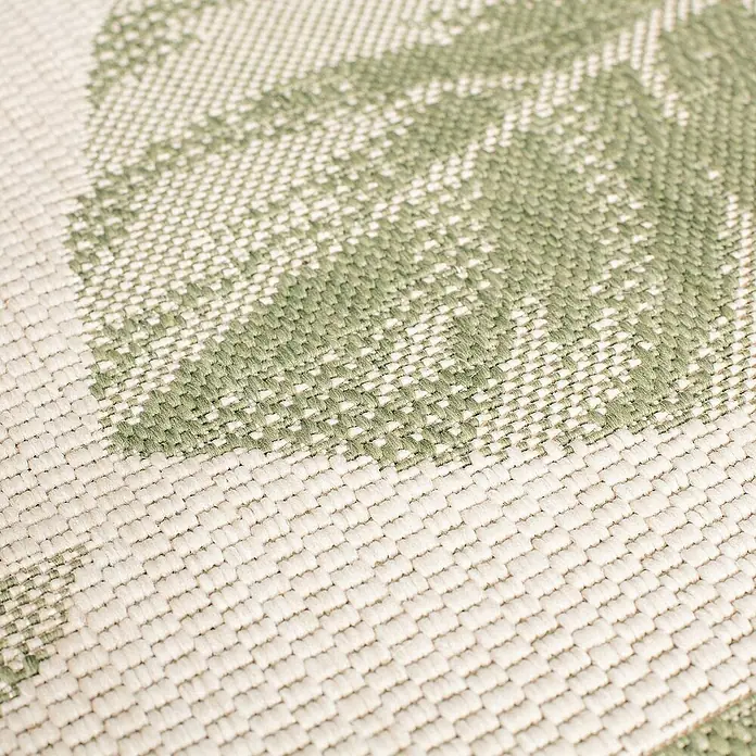 Dekoria Flachgewebeteppich - grün, beige - Nahaufnahme eines Outdoor-Teppichs mit einem grünen Blattmuster. Der Teppich hat eine gewebte Textur.