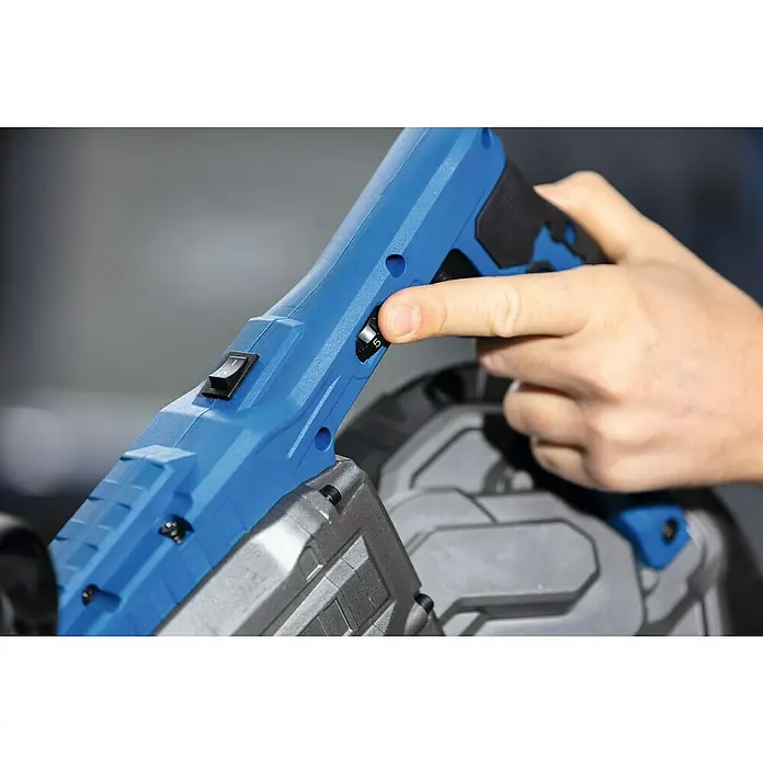 Scheppach Metallbandsäge MBS1200XT - 290 U/min, Schnittgeschwindigkeit: 0 m/min - 2,4 m/min, Sägebandlänge: 1.140 mm - Nahaufnahme einer Hand, die einen blauen Bandsägeschalter bedient, was die präzise Steuerung und Funktionalität des Geräts hervorhebt.
