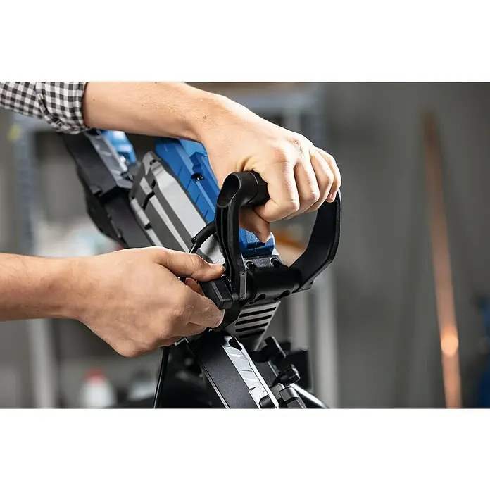 Scheppach Metallbandsäge MBS1200XT - 290 U/min, Schnittgeschwindigkeit: 0 m/min - 2,4 m/min, Sägebandlänge: 1.140 mm - Die Hände einer Person bedienen eine blaue und schwarze Säge. Hervorgehobenes Produkt: Säge für präzise Schnitte und professionelle Handwerker.