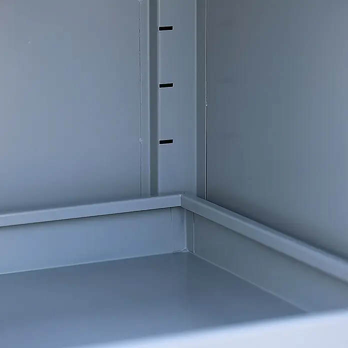 Lüllmann Gefahrstoffschrank - H x B x T: 195 x 91,6 x 42,2 cm, Lichtgrau/Rapsgelb, Fertig montiert, Anzahl Böden: 4 Stk. - Innenansicht eines grauen Metallschranks, der die robuste Konstruktion und die verstellbaren Schlitze für Regalböden zeigt.\n