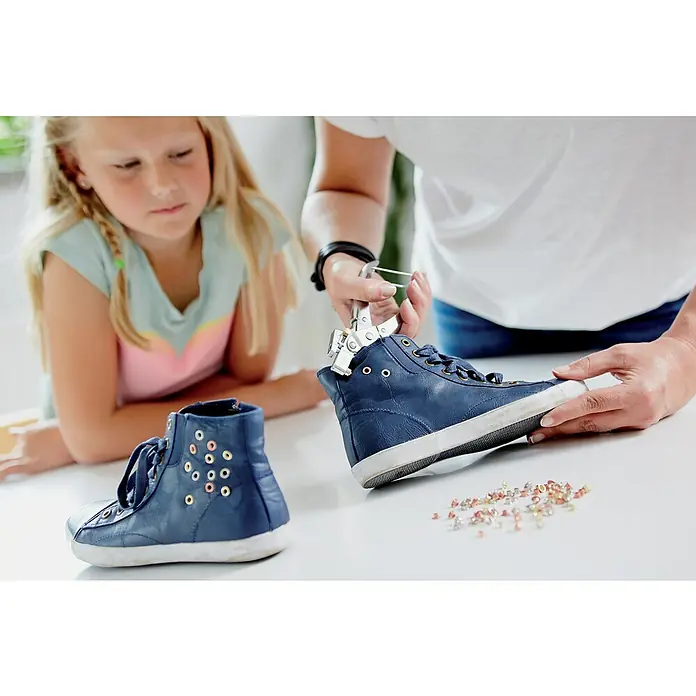 Rapid Ösenzange RP05 - Geeignet für: Ösen Ø 4 mm - Person befestigt Nieten an einem blauen Ledersneaker mit Nietenzange, während ein Mädchen zusieht. Individuelle Schuhgestaltung für Kinder.
