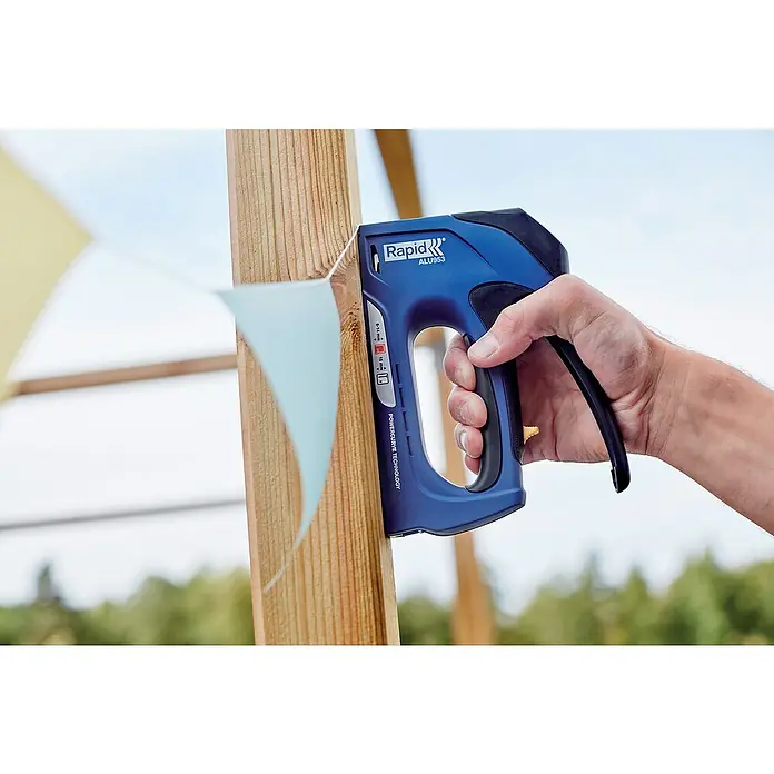 Rapid Handtacker ALU953 - Klammertiefe: 6 mm - 14 mm, Geeignet für: Klammern Typ 53 - Nahaufnahme eines Rapid ALU953 Tacker, der an einem Holzpfosten befestigt wird, während er von einer Hand gehalten wird.