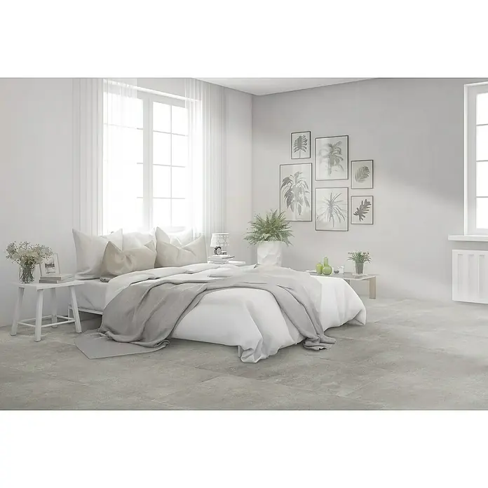 Feinsteinzeugfliese Rimini - 60 x 120 cm, Grigio, Matt - Schlafzimmer mit weißem Bett, grauem Überwurf, hellen Kissen und Pflanzendekoration.