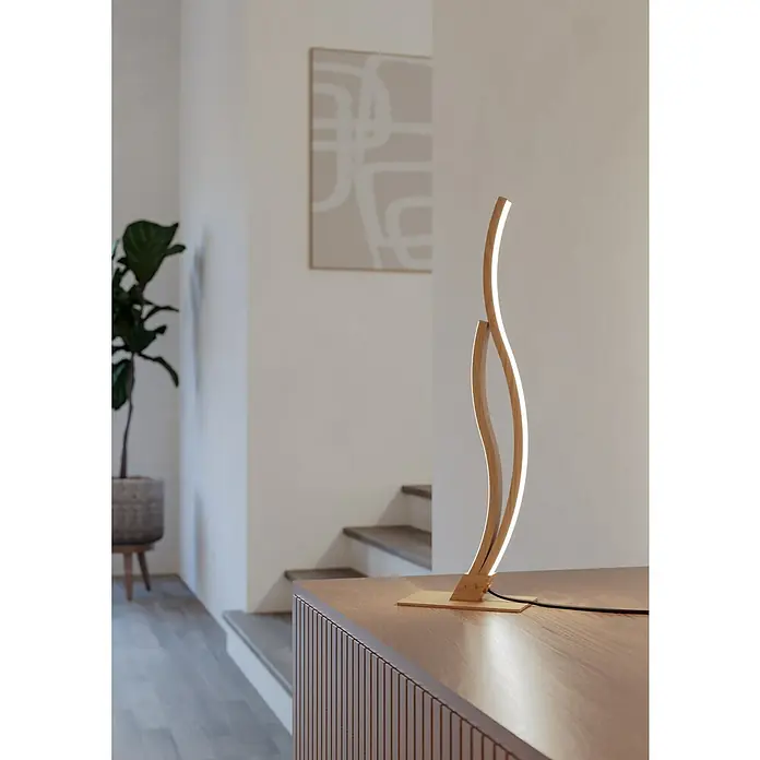 Eglo Grisolia Lámpara de sobremesa LED - 15 W, Altura: 45,5 cm, Beige, Blanco neutro - Una lámpara de mesa LED moderna de madera con formas curvas, suavemente iluminada, sobre una cómoda.