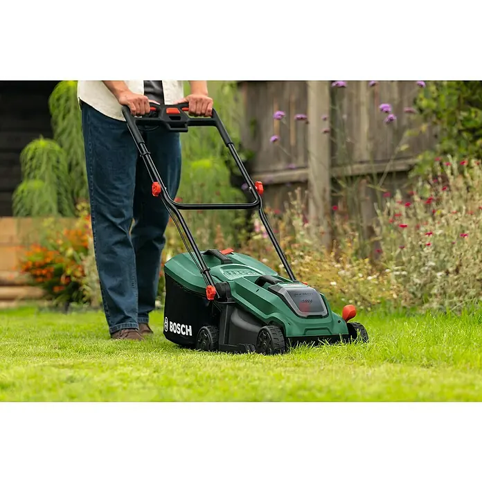 Bosch Power for All 18V Akku-Rasenmäher ROTAK18V-32 - Ohne Akku, Schnittbreite: 32 cm - Ein Mann benutzt einen Bosch Akku-Rasenmäher, um den Rasen zu mähen. Der Rasenmäher ist grün und schwarz.