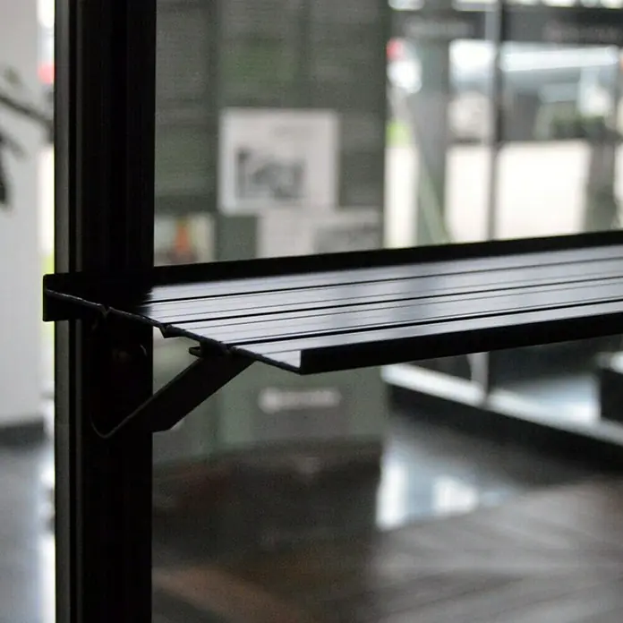 Juliana Gewächshaus-Regal - Passend für: Juliana Gewächshäuser - Nahaufnahme eines schwarzen Metallregals an einem Fenster, das modernes Design und Funktionalität zeigt.