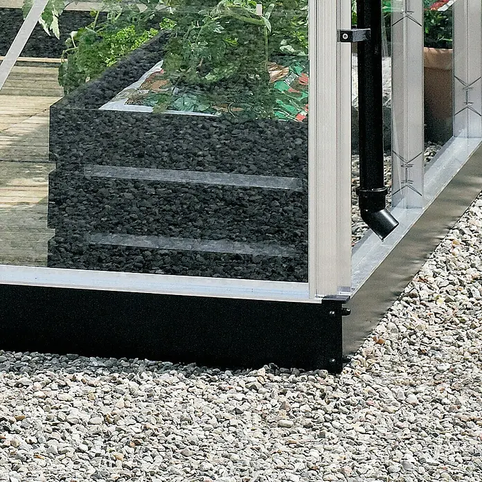 Juliana Gewächshaus Compact - Außenmaß inkl. Dachüberstand (B x T): 224 x 295 cm, Material Seitenwand: Glas, 3 mm, Silber/Schwarz - Detailaufnahme eines Gewächshauses mit Rahmen, schwarzer Basis und Kiesboden, das langlebige Materialien und funktionelles Design zeigt.