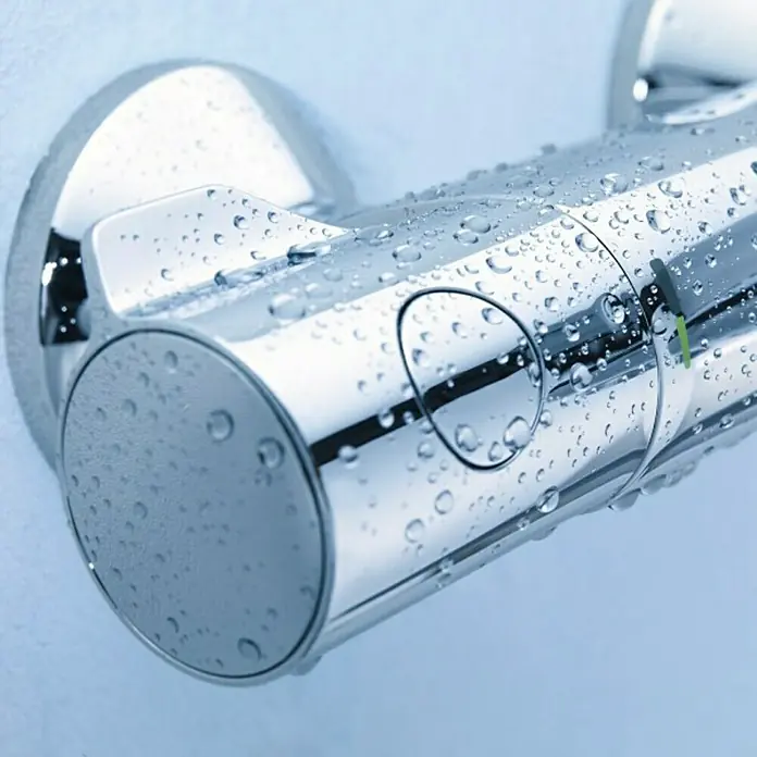 Grohe Wannenthermostat - Chrom, Glänzend - Nahaufnahme eines Thermostat-Duschventils mit Wassertropfen, das die präzise Temperaturregelung und das schlanke Design hervorhebt.