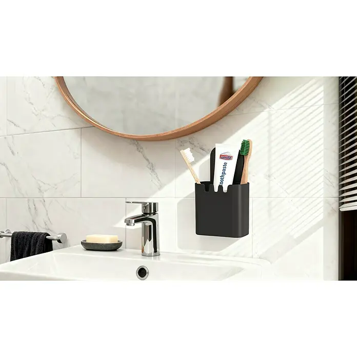 Venus Duschkorb Orsa - 8,7 x 10,7 x 17,5 cm, Schwarz - Dieses Badezimmer verfügt über einen Spiegel, ein Waschbecken und einen schwarzen Zahnbürstenhalter mit Zahnpasta und Zahnbürsten.
