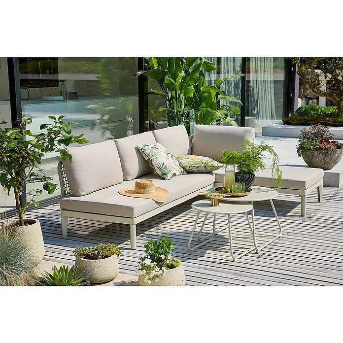 Sunfun Loungemöbel-Set Solo Rope/Sarah - 4 -tlg., Aluminium, Stahl, Olefin, Light-Greige - Eine stilvolle Outdoor-Lounge-Ecke mit beigen Polstern und Kissen mit tropischen Motiven, ergänzt durch Pflanzen und Beistelltische.