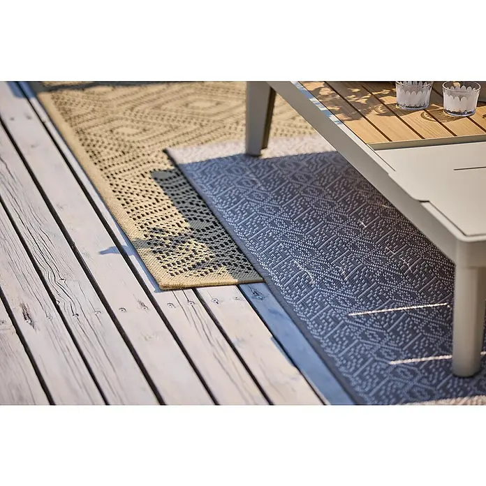 Outdoor-Teppich Wendeteppich Reno - Taupe, 220 x 160 cm, 100 % Polypropylen - Ein Nahaufnahme von zwei dekorativen Teppichen auf einer Holzterrasse, die eine gemütliche Atmosphäre im Außenbereich schaffen.