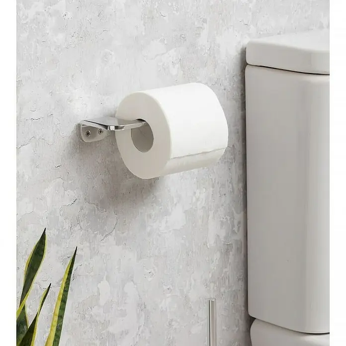 Tatay Flat Portarrollos papel higiénico - Sin tapa, Aluminio, Cromo - Primer plano de un rollo de papel higiénico en un soporte cromado, montado en una pared gris, junto a un inodoro blanco.