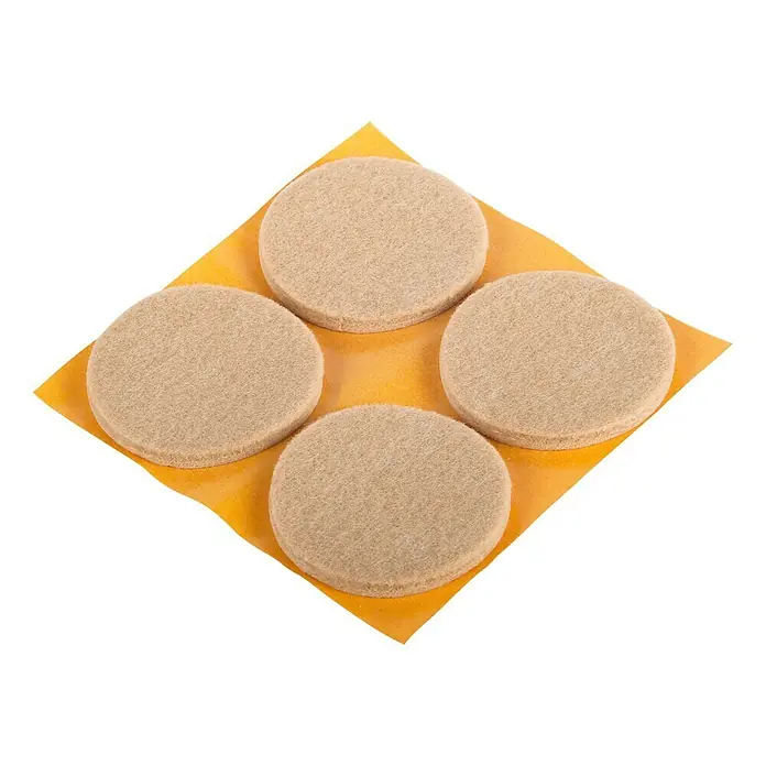 Stabilit Protector para muebles - Diámetro: 50 mm, Redonda, 4 ud. - Cuatro fieltros redondos beige sobre una hoja de soporte amarilla, ideales para proteger los suelos de los arañazos de los muebles.