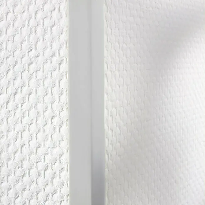 LOGOCLIC Winkelleiste Hellgrau - 275 cm x 30 mm x 30 mm - Nahaufnahme einer weißen strukturierten Wand mit einem schlanken vertikalen Paneel, das die Textur unterstreicht.