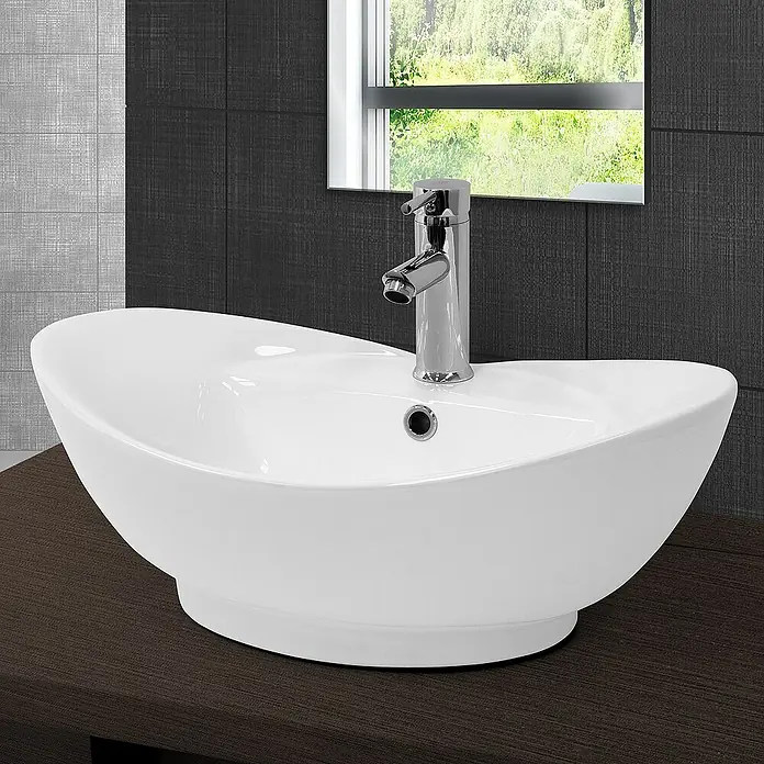 LuxeBath Aufsatzwaschbecken Handwaschbecken Weiß inkl. Ablaufgarnitur mit Überlauf - Ohne Spezialglasur, Weiß - Elegantes Waschbecken mit einem modernen Chrom-Wasserhahn auf einer dunklen Holzoberfläche vor einer stilvollen Wand und Fenster.