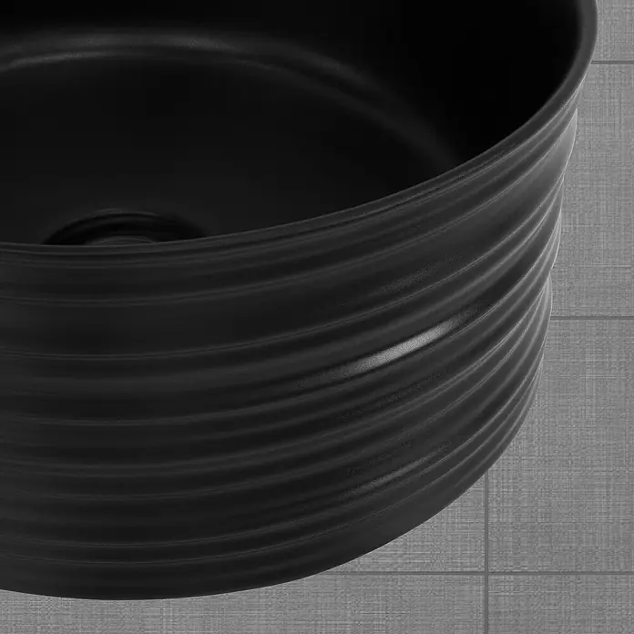 LuxeBath Aufsatzwaschbecken Rund Ø41x18 cm Schwarz ohne Ablaufgarnitur - Ohne Spezialglasur, Schwarz - Nahaufnahme einer schwarzen, geriffelten Keramikspüle, die modernes Design und funktionale Eleganz vereint.