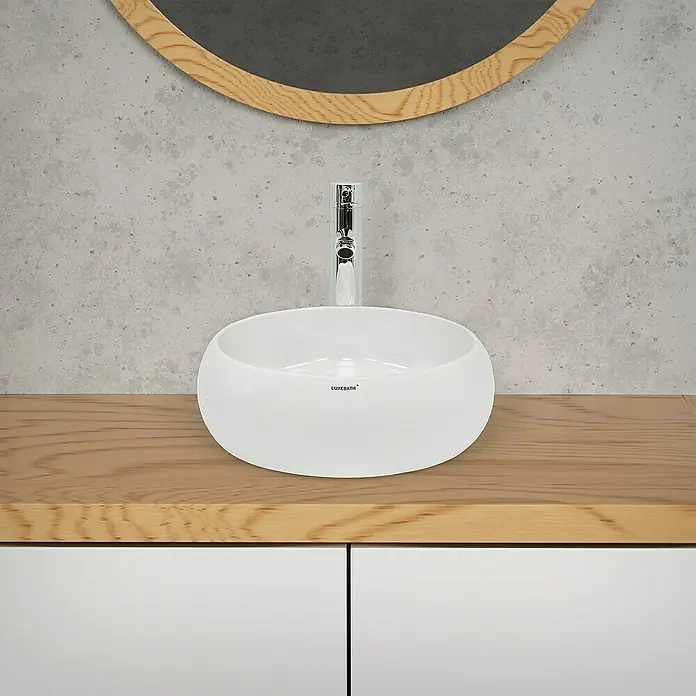 LuxeBath Aufsatzwaschbecken Aufsatzwaschtisch Waschschale Rund Weiß Spülbecken - Ohne Spezialglasur, Weiß - Modernes Badezimmerwaschbecken mit Armatur auf einem Holzunterschrank und einem runden Spiegel im Hintergrund.