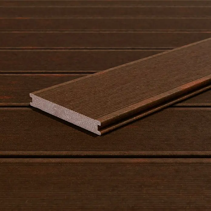 Kovalex WPC-Terrassendiele Massiv mit Struktur nach Maß - Walnuss, 500 x 14,5 x 2 cm - Nahaufnahme einer einzelnen braunen Terrassendiele aus WPC, die die Holzstruktur und die Nut-Feder-Verbindung hervorhebt.\n