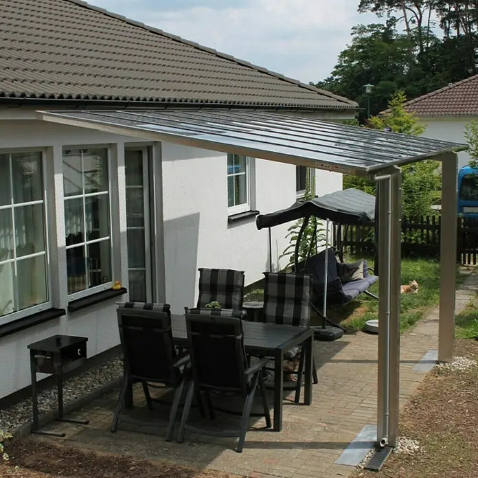Ximax Carport LINEA 80 - Außenmaß inkl. Dachüberstand (B x T): 2,73 x 4,95 m, Einzelcarport, Edelstahloptik - Ein Terrassendach aus transparentem Material mit einem stabilen, grauen Metallrahmen bietet Schutz und eine moderne Optik für den Außenbereich.