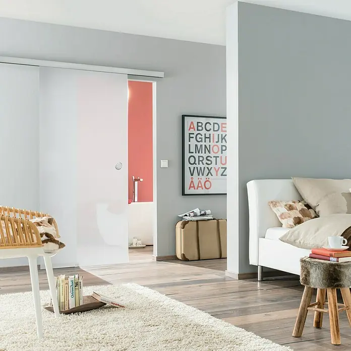 Diamond Doors Glasschiebetür Luminato - 935 x 2.058 mm, Einscheibensicherheitsglas (ESG) - Ein modernes Zimmer mit einer eleganten Schiebetür, die einen Blick ins Badezimmer freigibt, ergänzt durch ein stilvolles Interieur.