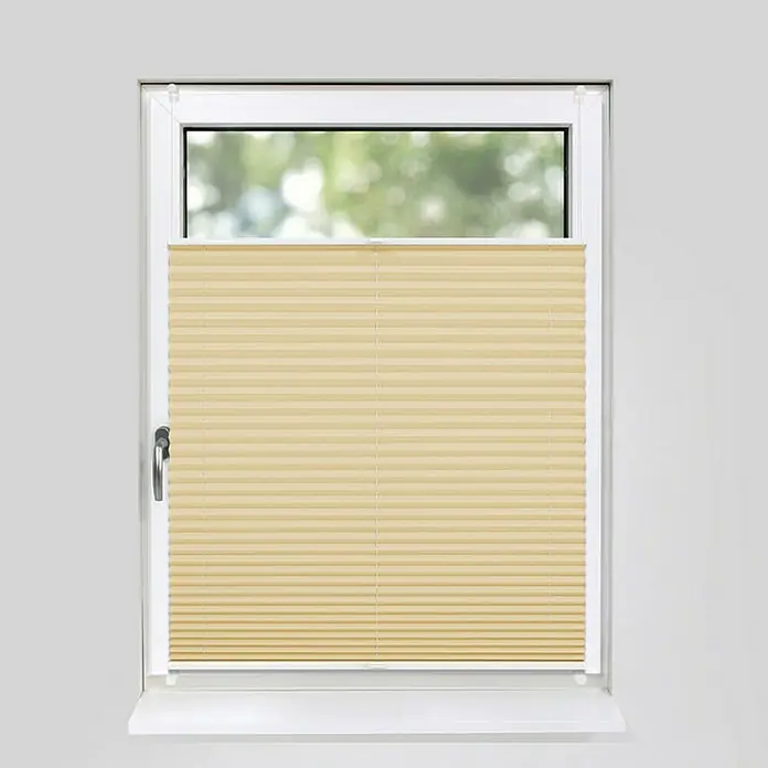 Deco-Raum Plissee ohne Bohren Basic - B x H: 115 x 150 cm, Beige - Bild einer beigen Plissee-Jalousie, die an einem weißen Fensterrahmen in einem hellgrauen Raum montiert ist und für Privatsphäre sorgt.