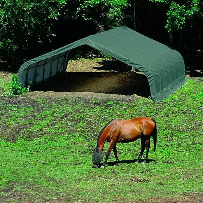 ShelterLogic Garage - Außenmaß inkl. Dachüberstand (B x T): 670 x 610 cm, Kunststoff, Grün - Eine grüne Pferdeunterstand Plane bietet Schutz vor dem Wetter, während ein braunes Pferd auf der grünen Wiese grast.