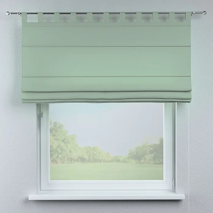 Dekoria Raffrollo -  - Ein grünes Raffrollo hängt vor einem Fenster, das einen Blick auf eine grüne Landschaft bietet. Das Rollo ist gerafft und verleiht dem Raum eine gemütliche Atmosphäre.