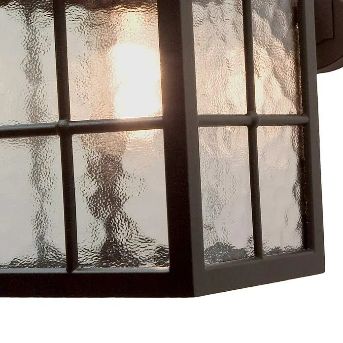 Elstead Außenwandleuchte Winchester - 60 W, 31 x 40 x 40 cm, Schwarz, IP23 - Nahaufnahme einer Außenleuchte mit einem strukturierten Glasgehäuse und einem dunklen Metallrahmen, die ein warmes Licht ausstrahlt.