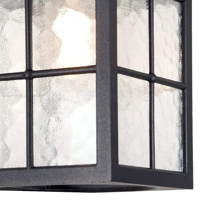 Elstead Außenleuchte Winchester - 60 W, Farbe Gehäuse: Schwarz, 18,5 x 18,5 x 28 cm, Mit Leuchtmittel - Nahaufnahme einer schwarzen Außenleuchte mit strukturiertem Glas, die ein warmes Licht ausstrahlt.\n