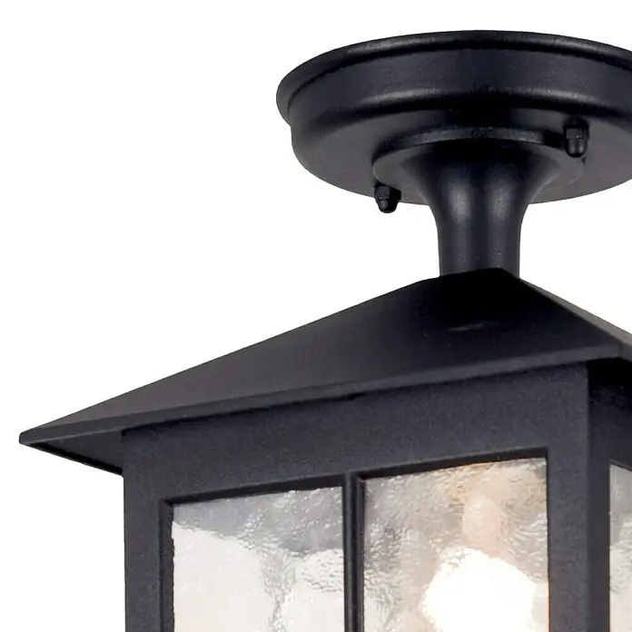 Elstead Außenleuchte Winchester - 60 W, Farbe Gehäuse: Schwarz, 18,5 x 18,5 x 28 cm, Mit Leuchtmittel - Nahaufnahme einer schwarzen Außenleuchte mit klarem, strukturiertem Glas, die einen warmen Schein wirft und robuste, stilvolle Beleuchtung bietet.