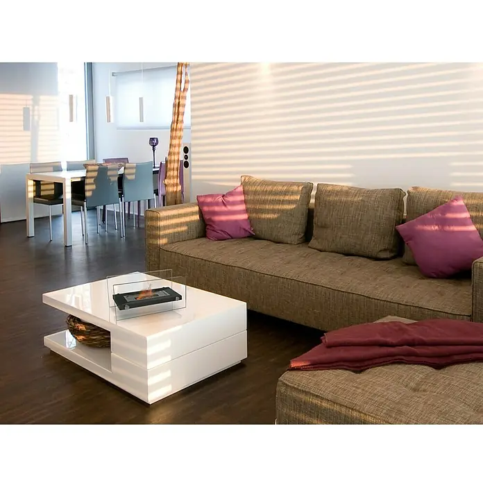 Purline Chimenea de bioetanol Oniros - Acero inoxidable, Negro - Una sala de estar moderna con una mesa de centro blanca, una chimenea de bioetanol y un cómodo sofá marrón con almohadas moradas.
