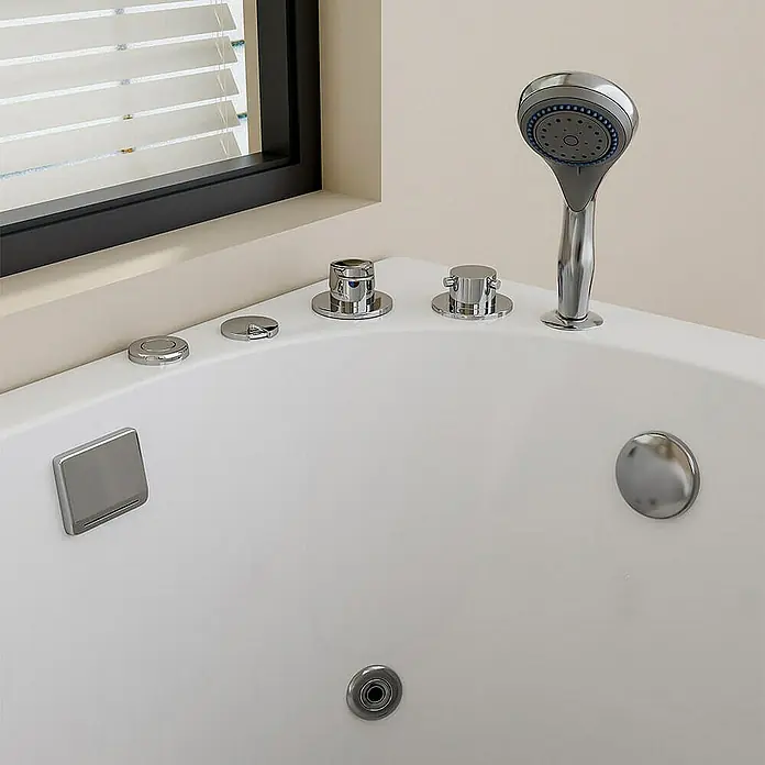 Home Deluxe Badewanne VITAL M - Weiß - Nahaufnahme einer weißen Whirlpool-Badewanne mit Chromarmaturen, einem Duschkopf und einem Fenster mit Jalousien.