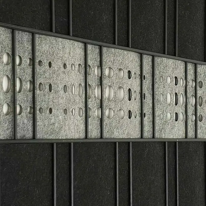 zaun|zu Sichtschutzstreifen Dekor Bubble - 2,6 m x 19 cm x 0,1 cm, Hellgrau - Nahaufnahme eines perforierten Akustikpaneels mit grauem Filz, eingefasst in dunklen Metallrahmen.